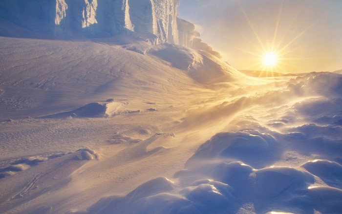 Sunlight over a snowy landscape with ice formations