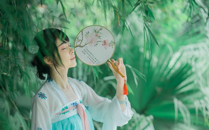 Woman in traditional Chinese dress holding a fan