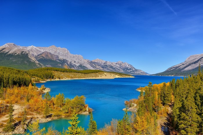 Turquoise lake surrounded by autumn trees and mountains