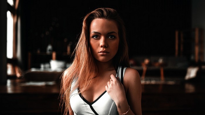 Woman with long brown hair in a white top
