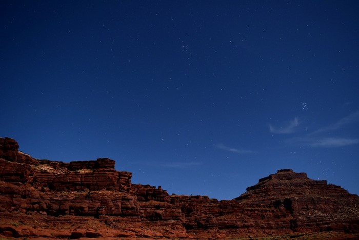 Red rock formations under a starry night sky