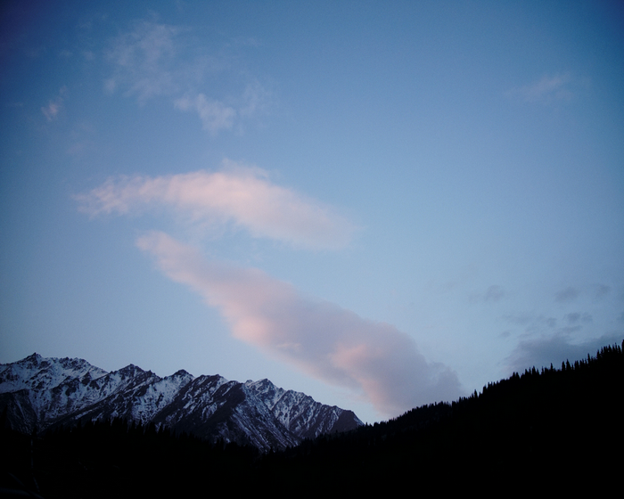 Snow-capped mountains at dusk with pink clouds