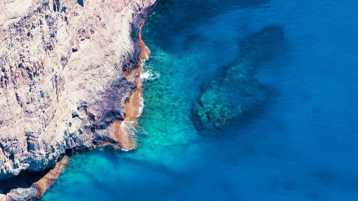 Rocky coastline meeting clear blue ocean water