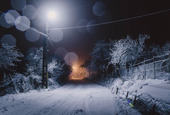 Snowy road at night with street light