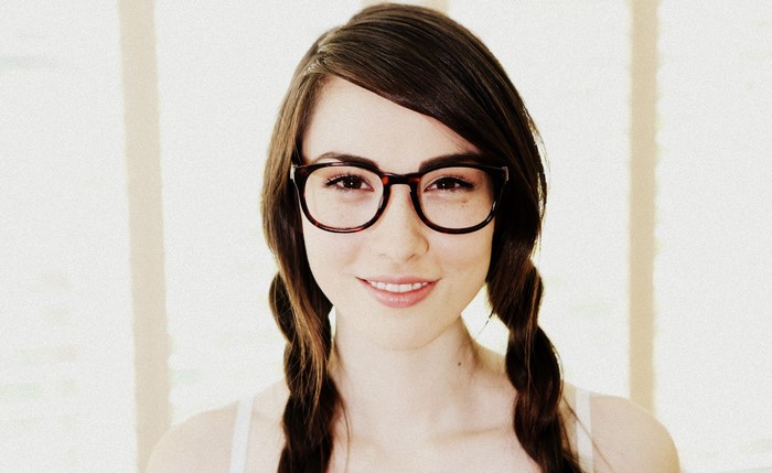 Emily Grey wearing glasses with braided hair