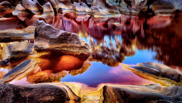 Rio Tinto river with colorful rock formations and reflections