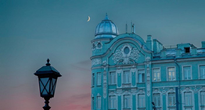 Building with dome and crescent moon at dusk
