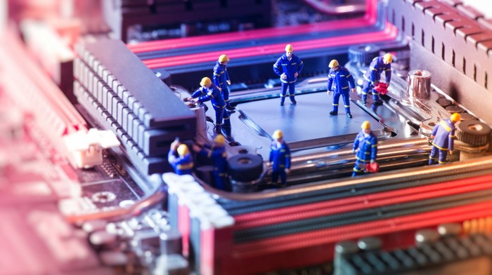 Miniature workers on a computer motherboard