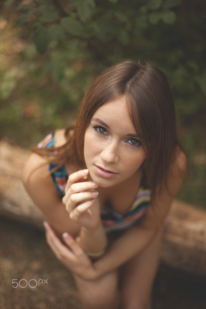 Woman with long brown hair and blue eyes looking up