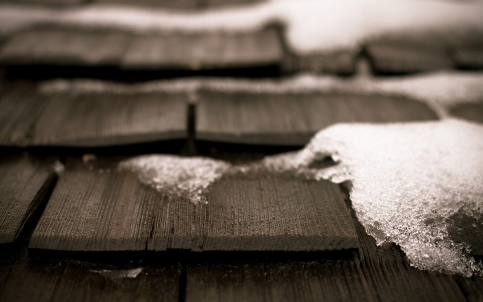 Close up of snow on wooden roof shingles