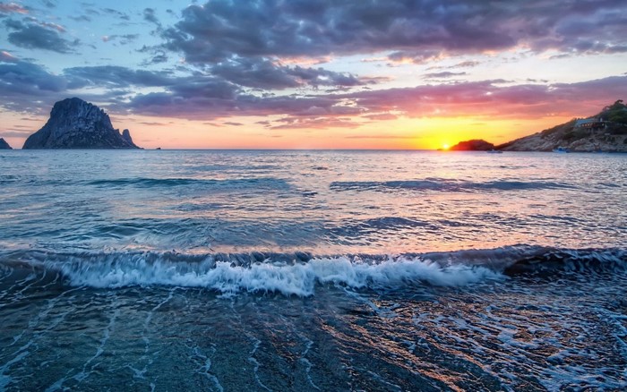 Sunset over the sea with a rocky island