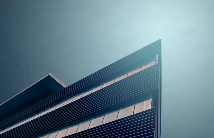 Modern building facade with geometric lines against a blue sky