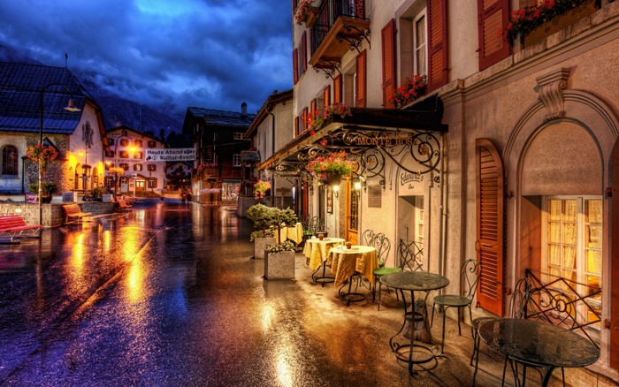 Street cafe at night in a village with wet streets