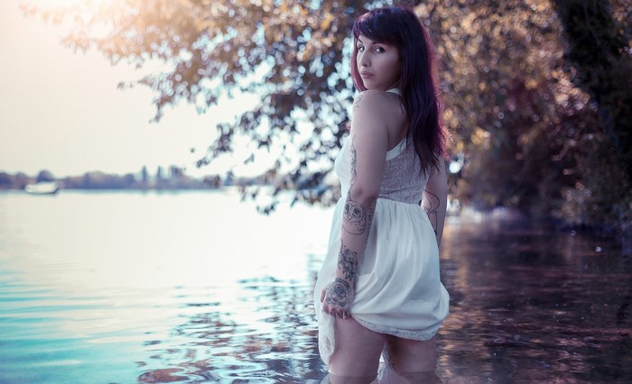 Woman with tattoos standing in water