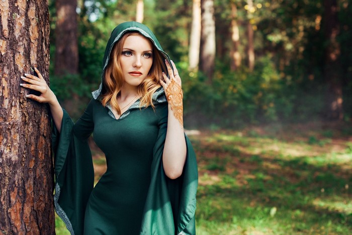 Woman in green hooded dress with henna in forest