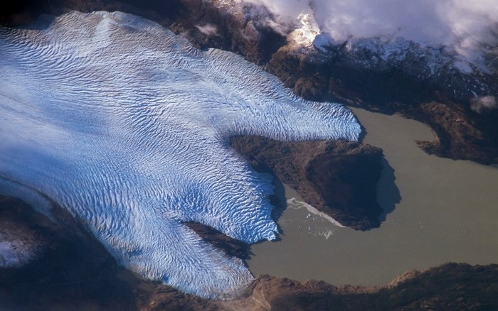 Aerial view of a glacier flowing into a lake in Chile