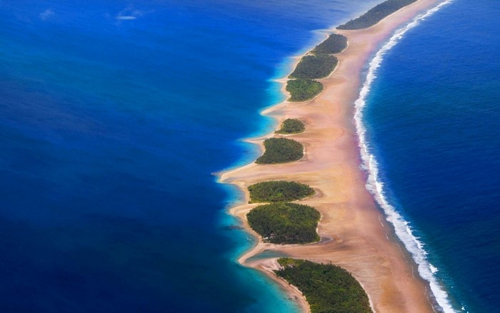 Aerial view of a tropical island chain with lush green islets and sandy beaches.