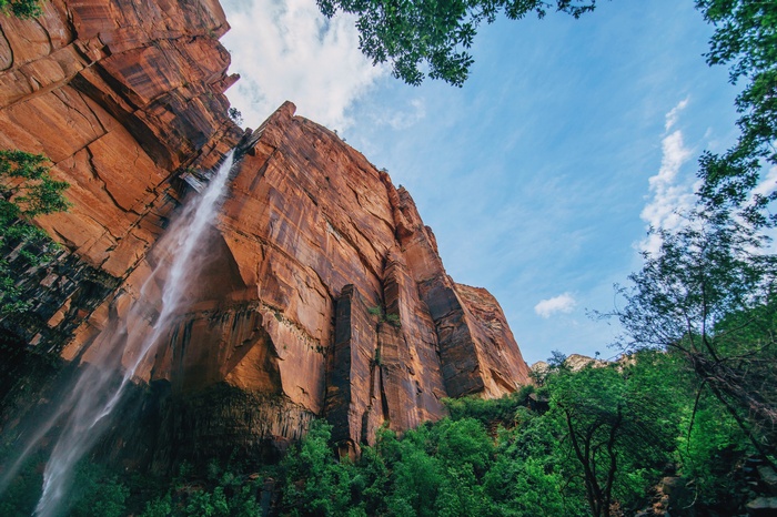Waterfall cascading down a red rock cliff face