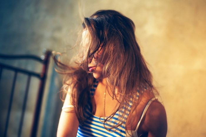 Woman with long brown hair wearing a blue and white striped top