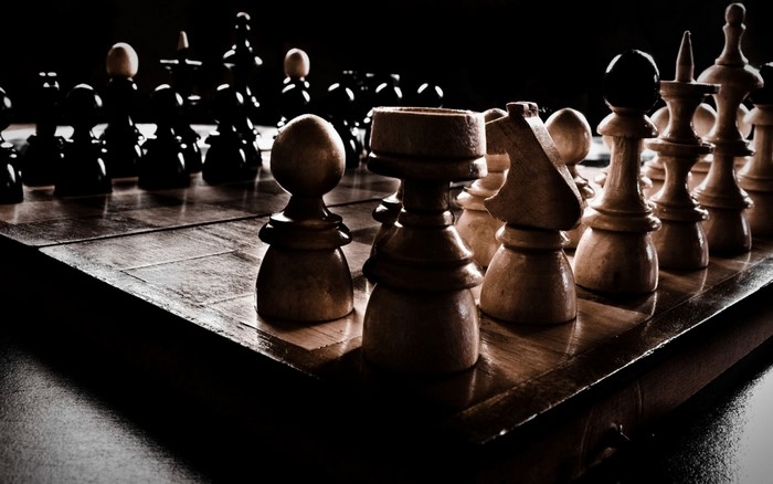 Dimly Lit Wooden Chessboard with Pieces