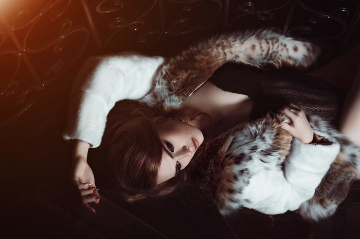 Woman in fur coat lying down