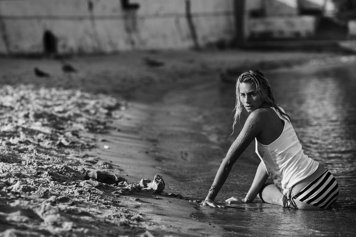 Woman in white tank top and striped shorts on a beach
