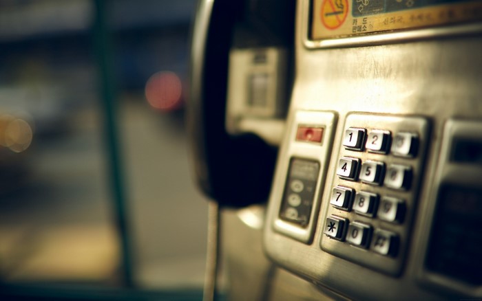 Close-up of a payphone keypad with bokeh background