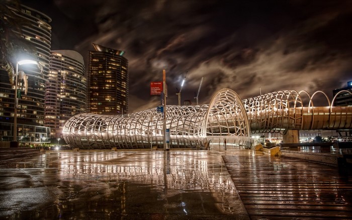 Cityscape at night with a modern bridge and reflections