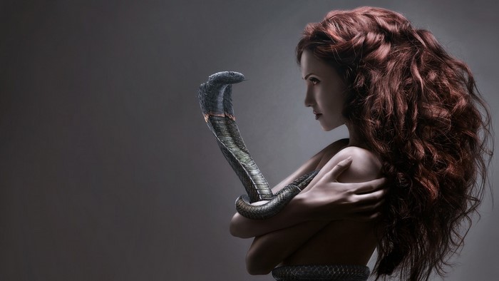 Woman with a cobra wrapped around her arm
