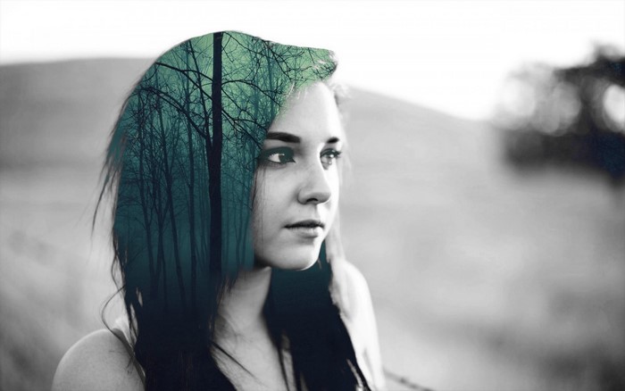 Double exposure portrait of a woman with a forest in her hair