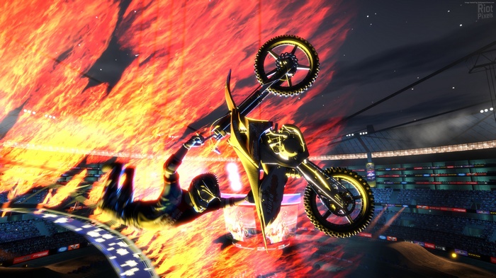 Motocross rider performing a stunt over fire in a stadium