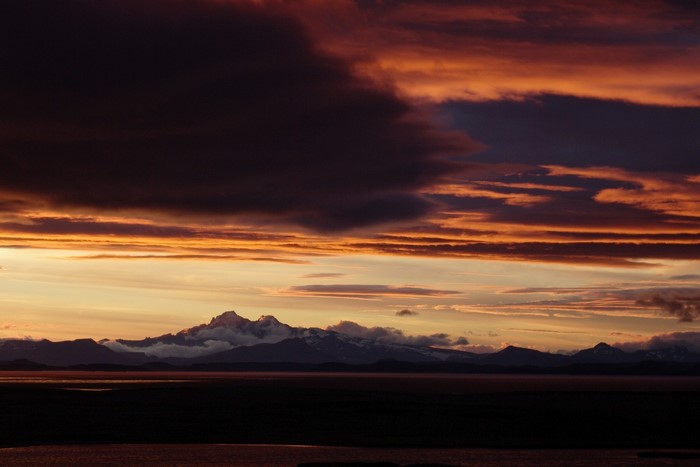 Sunset over mountains and water with dramatic clouds
