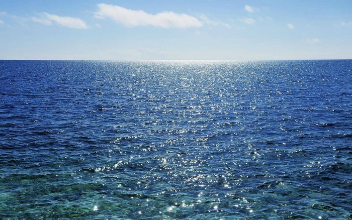Ocean horizon with sparkling water and clouds