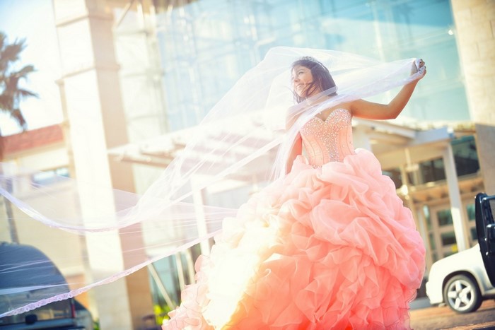 Woman in a pink quinceañera dress with a veil