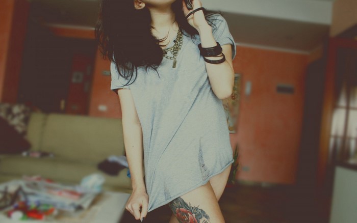 Woman in grey t-shirt with leg tattoo