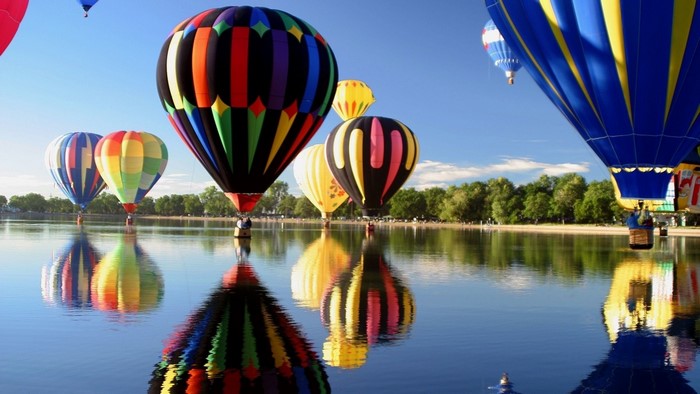 Hot air balloons reflected in a lake