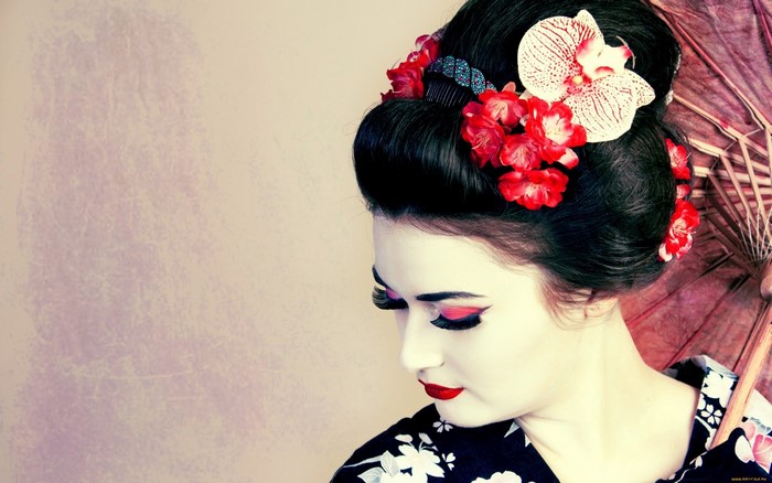 Woman in Geisha attire with flowers and umbrella