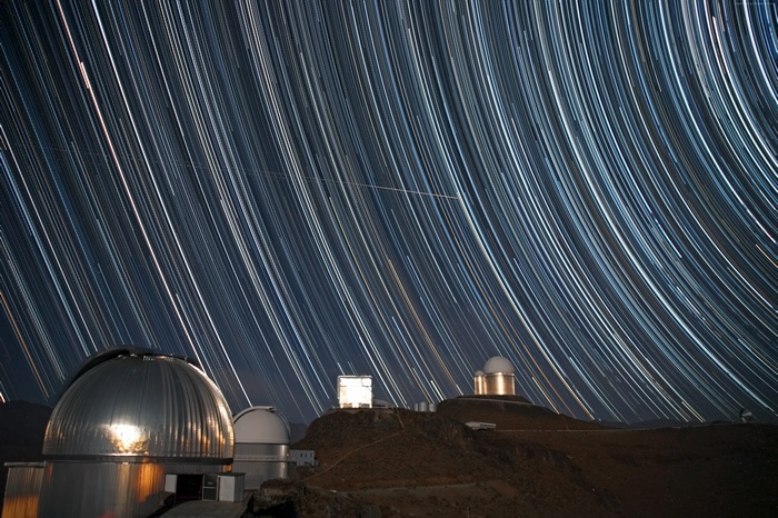 Observatory domes under star trails at night