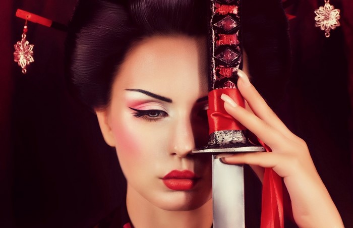 Woman in Geisha makeup holding a katana