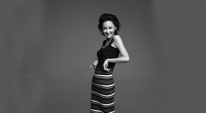 Asian woman in striped dress posing for photoshoot