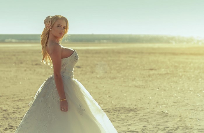Bride in Elegant Wedding Dress on Sandy Beach