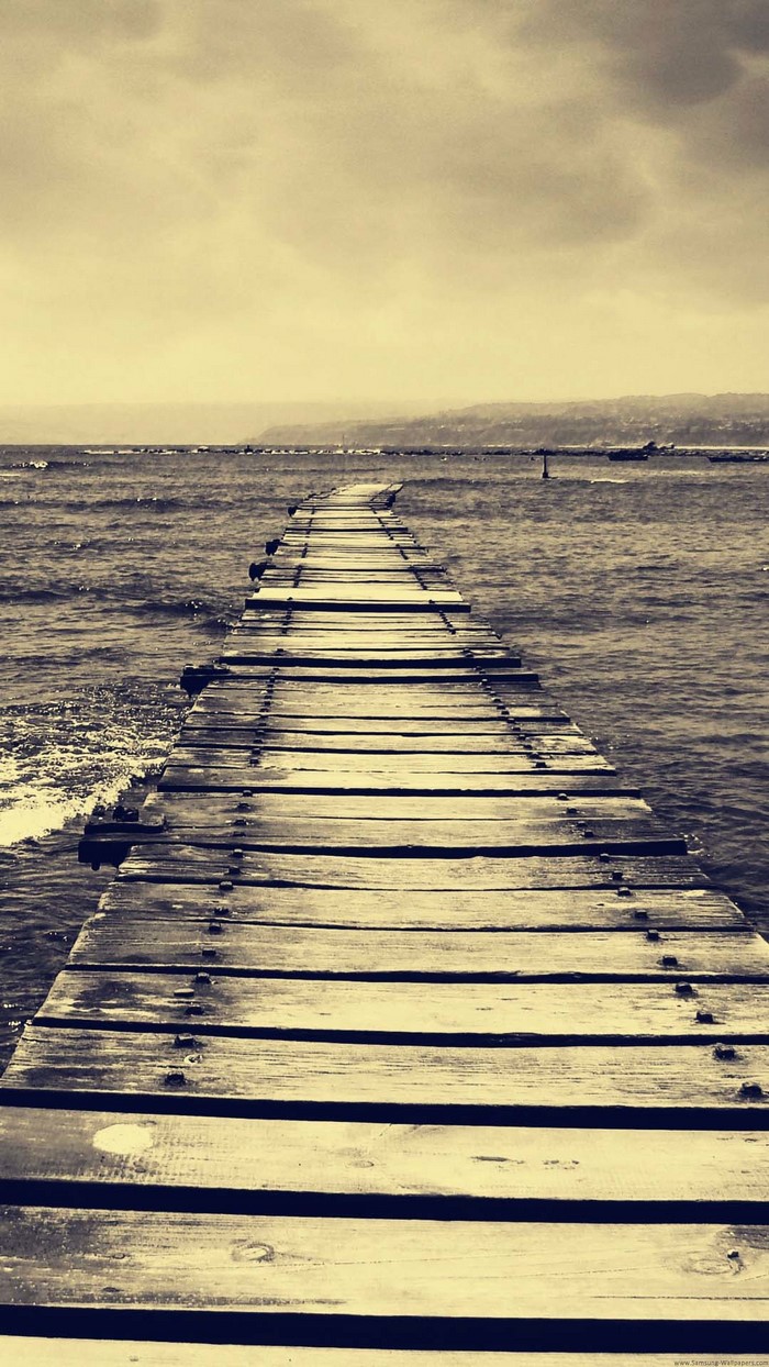 Wooden pier extending into the sea at sunset