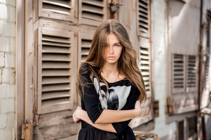 Woman with long brown hair in a black shirt