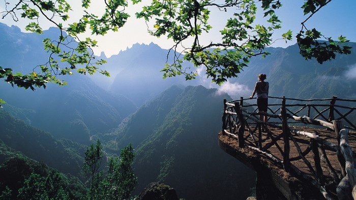 Woman on a scenic viewpoint overlooking mountains
