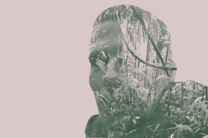 Double exposure of a person's head and a tropical forest