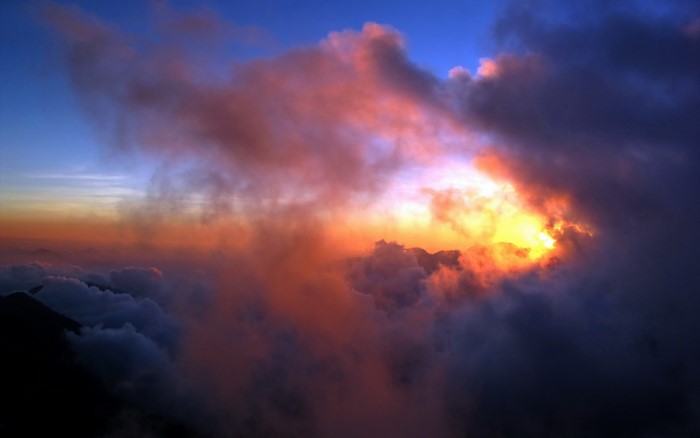 Sunset clouds over mountains with sunlight