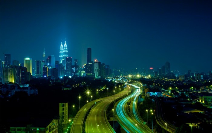 Kuala Lumpur cityscape at night with Petronas Towers and highway