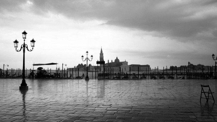 Venice cityscape with gondolas and lampposts on a cloudy day