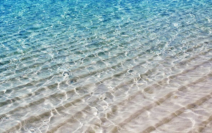 Clear turquoise water over sandy beach