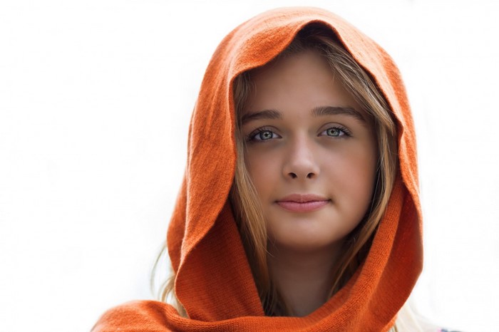 Young woman with blonde hair wearing an orange hood
